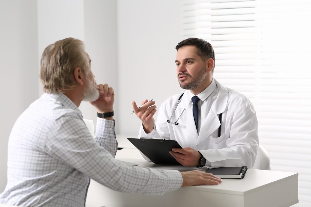 Man discussing testosterone replacement therapy guide with healthcare provider during consultation