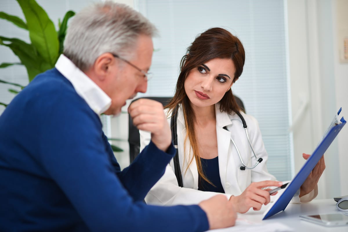 Older man consulting with a doctor to understand andropause vs low testosterone and his treatment options
