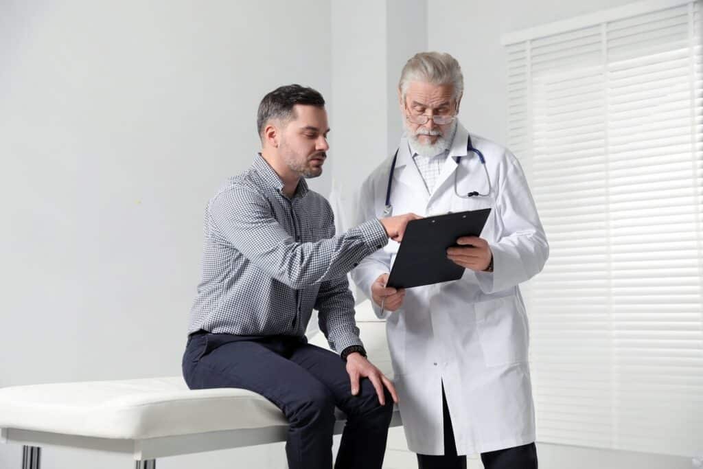 Doctor reviewing estrogen levels on TRT with male patient during consultation