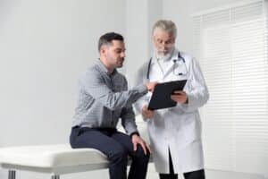 Doctor reviewing estrogen levels on TRT with male patient during consultation