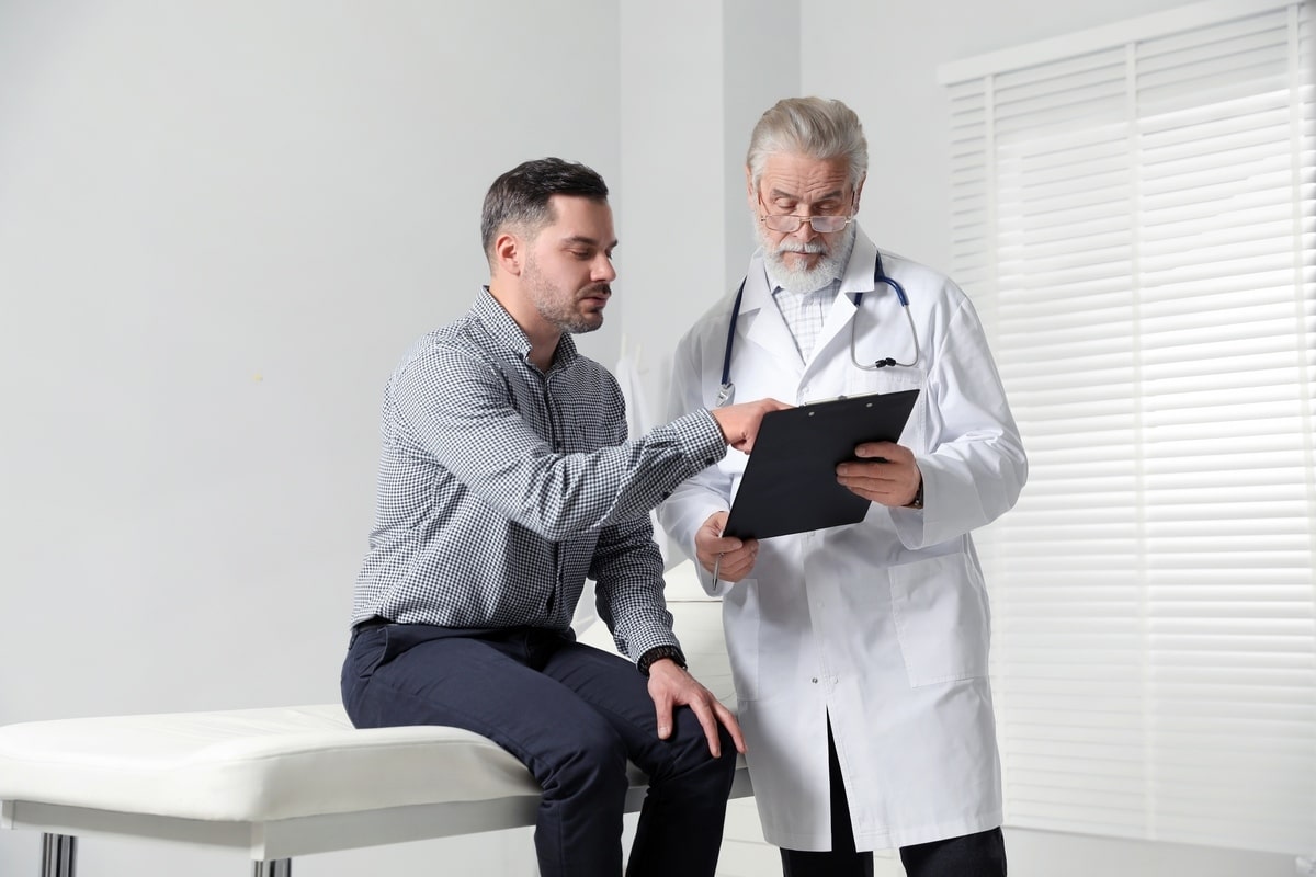 Doctor reviewing estrogen levels on TRT with male patient during consultation