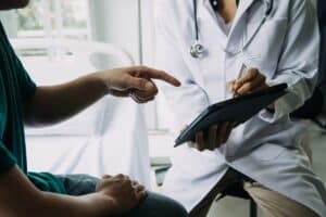 Patient discussing TRT dose adjustment with doctor during consultation