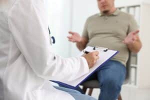 Overweight man discussing trt and medical weight loss options with provider during clinical consultation