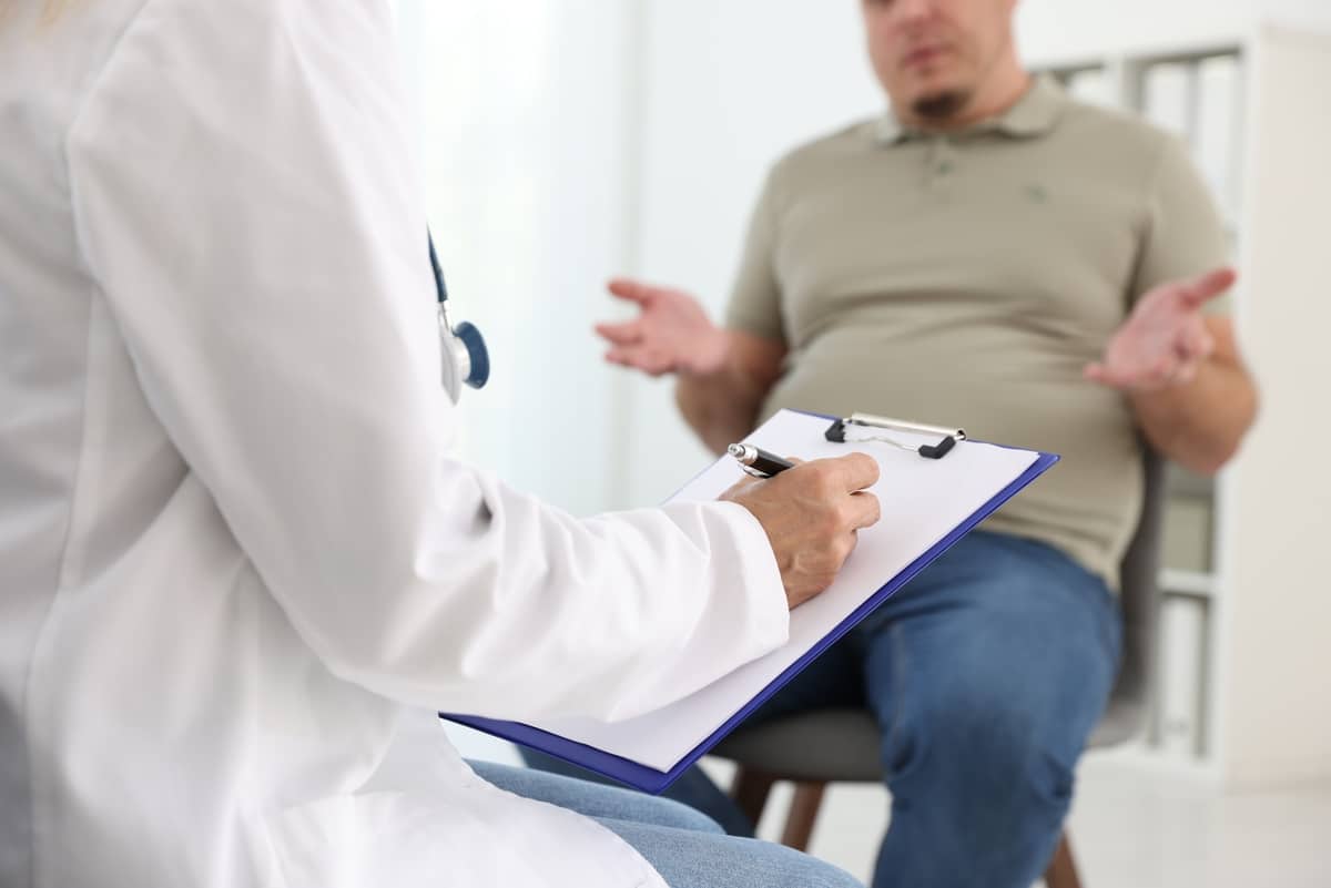 Overweight man discussing trt and medical weight loss options with provider during clinical consultation